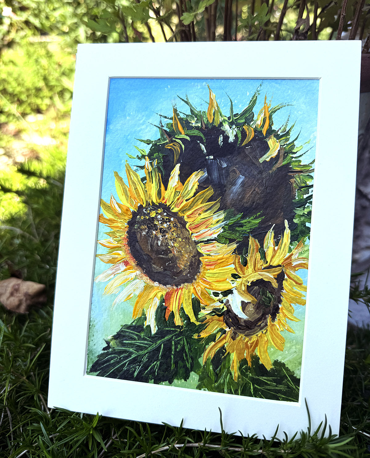 Framed painting of sunflowers on grass