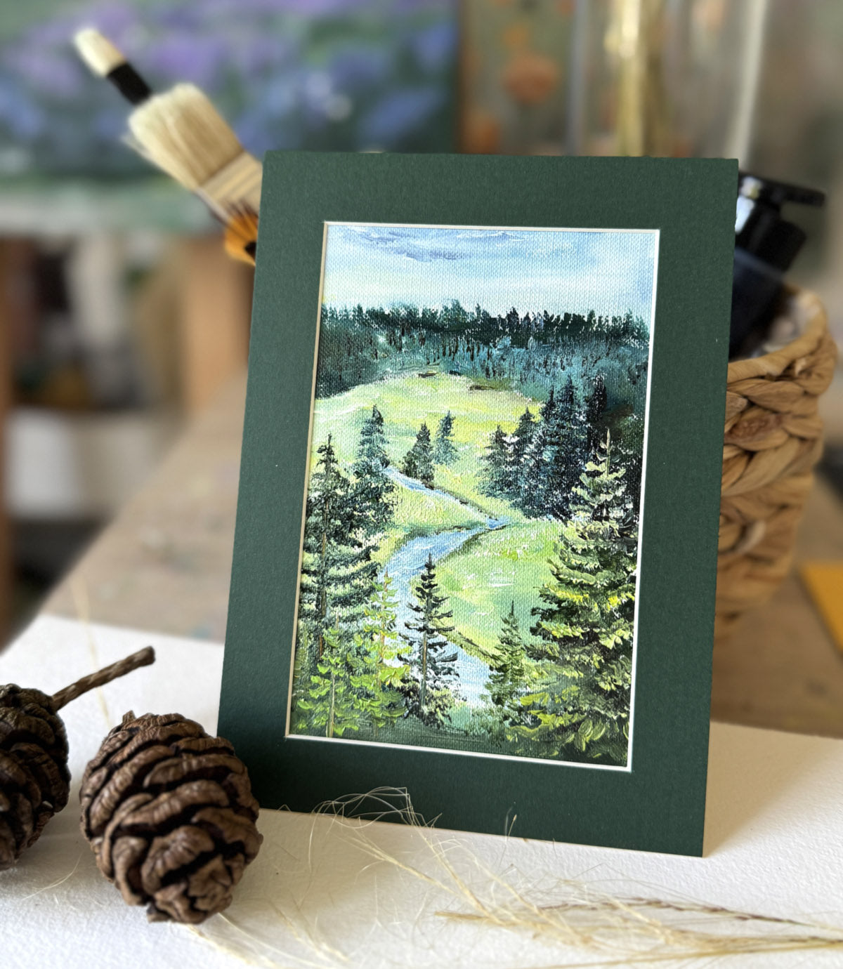 Miniature oil painting of a hillside river and pine forest, original landscape artwork by Katie Koroleva.