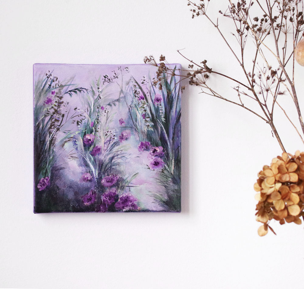 Painting of purple flowers on a white surface with dried plants.