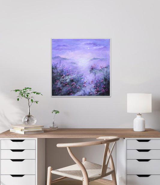 Framed artwork of a purple landscape with flowers on a wall above a desk.