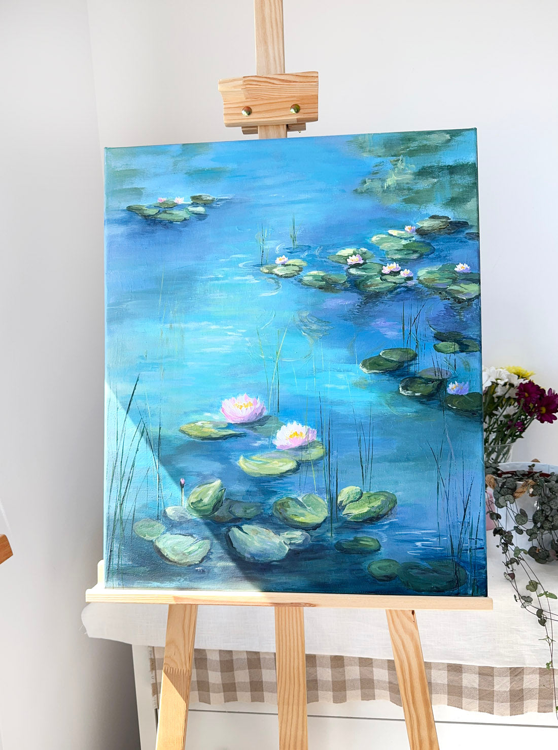 Painting of water lilies on a blue pond monet style