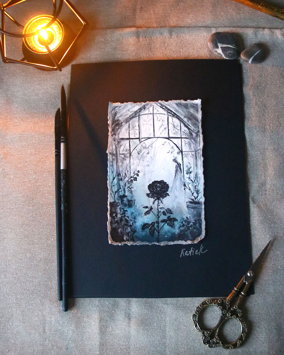 Artistic depiction of a rose and window on a black background with a candle and tools.