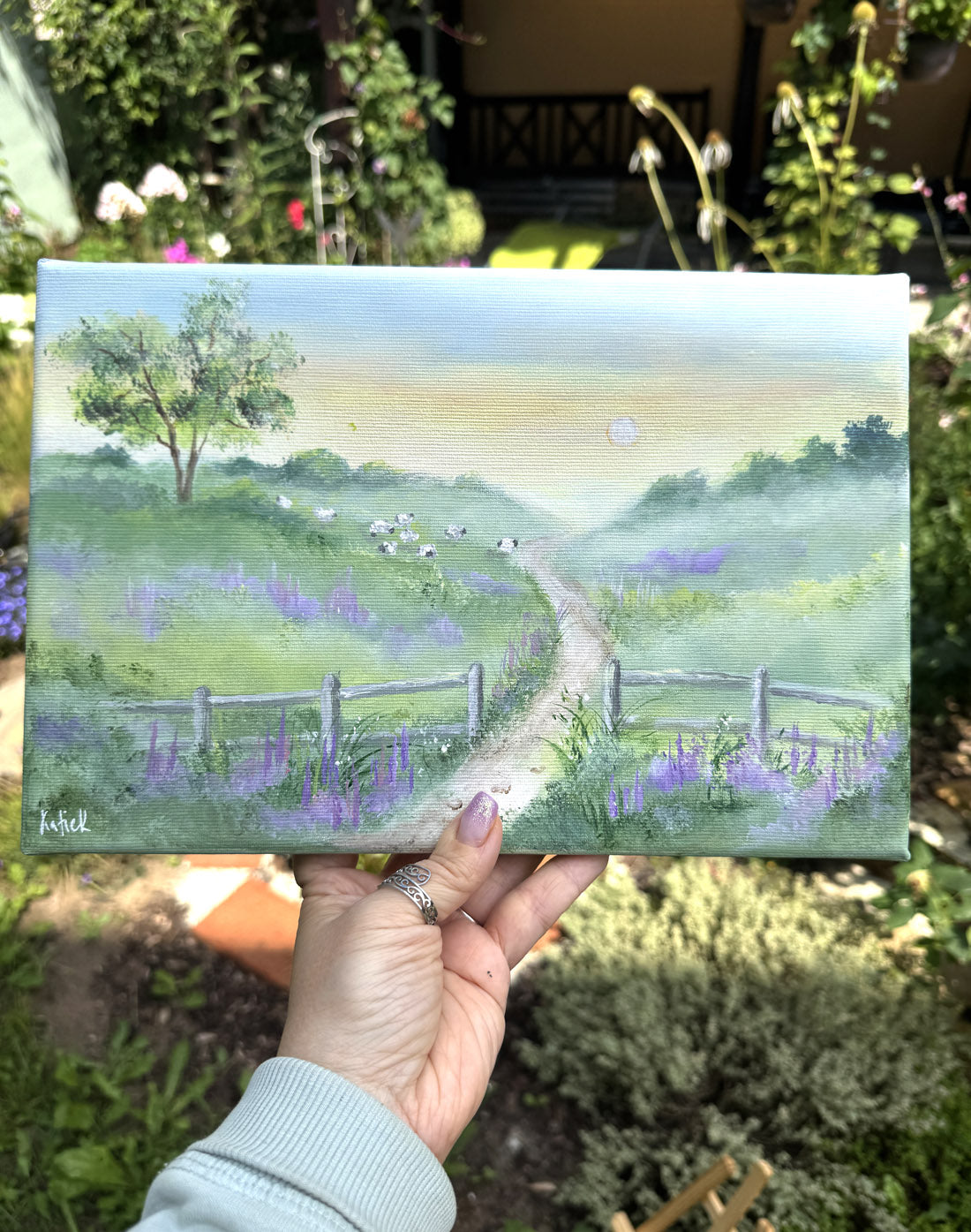 a painting of a pastoral scene with a path, trees, sheep and flowers.