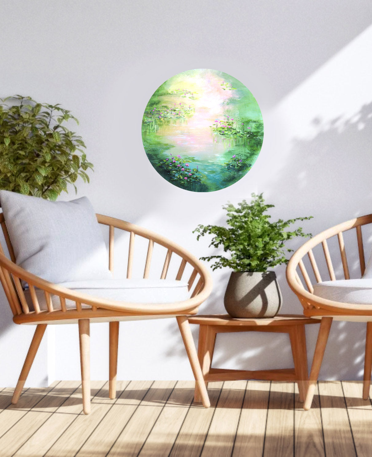 Round wall art of a garden scene above a wooden chair with white cushion on a wooden deck.