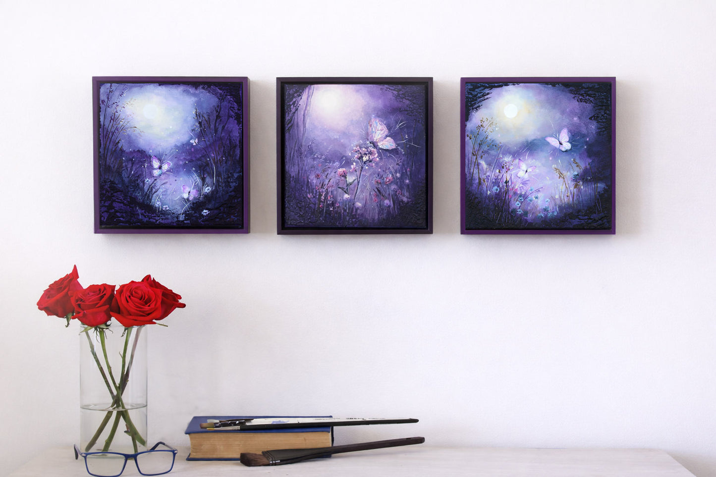 Purple dusk framed landscapes with luminous glow, delicate flowers, and moths drawn to light